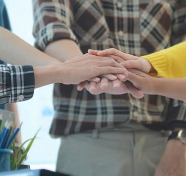 Close up view of young business people stacking hands together. Business startup, Unity and teamwork concept.